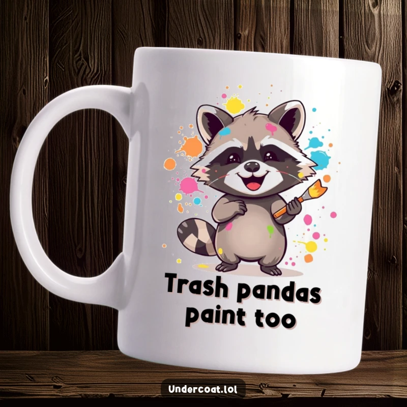 Funny raccoon mug showing a joyful raccoon splattering vibrant paint with a brush, embodying messy artistic fun.